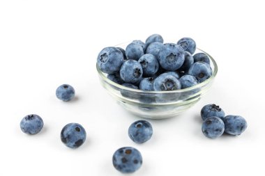 blueberries in a glass bowl on a white background.