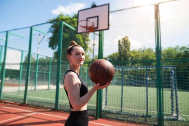 Basketbol sahasında basketbol oynayan genç bir kız, aktif bir hafta sonu..
