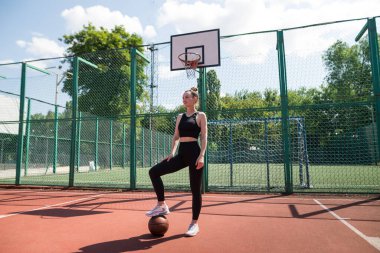 Basketbol sahasında basketbol oynayan genç bir kız, aktif bir hafta sonu..