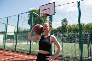 Basketbol sahasında basketbol oynayan genç bir kız, aktif bir hafta sonu..