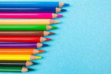 Kopya alanı olan mavi arkaplan üzerindeki renkli kalemler.