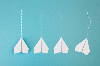 Yeni fikirler yaratıcılık ve farklı yenilikçi çözümler. İş konsepti. Bir grup kağıttan uçak, bir uçak diğer yönde uçuyor, farklı yönde..