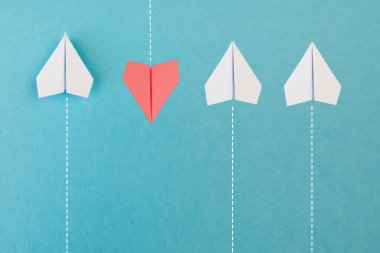 Yeni fikirler yaratıcılık ve farklı yenilikçi çözümler. İş konsepti. Bir grup kağıttan uçak, bir uçak diğer yönde uçuyor, farklı yönde..