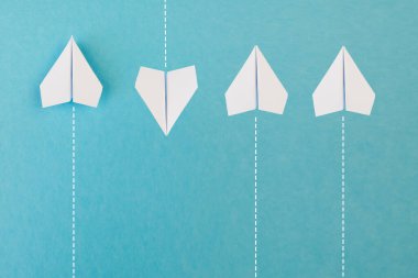 Yeni fikirler yaratıcılık ve farklı yenilikçi çözümler. İş konsepti. Bir grup kağıttan uçak, bir uçak diğer yönde uçuyor, farklı yönde..