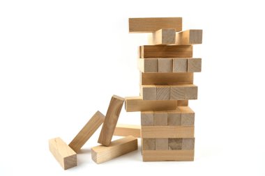 Beyaz arka planda izole edilmiş bloklardan yapılmış ahşap bir kuleye yakın plan. Eşit olmayan ahşap kirişlerden bir kule. Çeviklik, mantık ve koordinasyon için bir ders. Ev eğlencesi. Denge. Yakın plan. İzolasyon, beyaz arkaplan