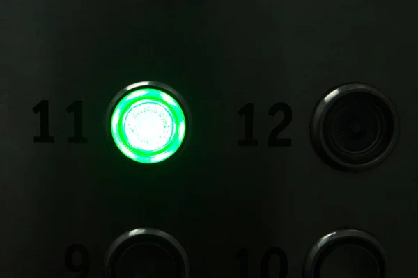Illuminated white button in darkness - elevator button glowing in dark. The elevator goes to the 11th floor.