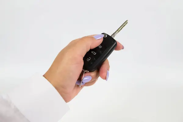 car keys in a woman\'s hand on a white background
