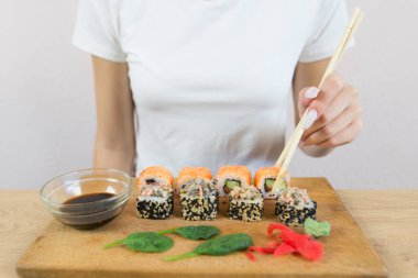 Suşi yiyen genç bir kadın. Kesilmiş fotoğraf