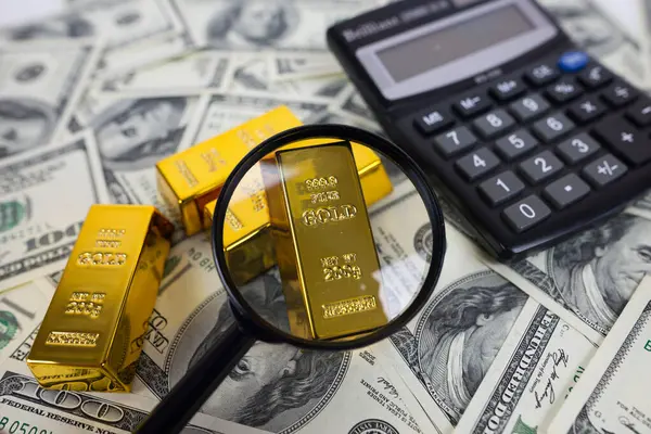 Золотые Слитки Лежат Калькулятором Увеличительным Стеклом Рядом Большим Количеством Долларов Стоковое Фото