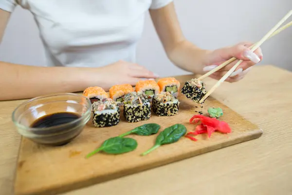 Young woman eating sushi. Cropped photo