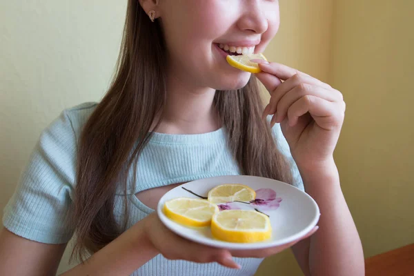 beautiful woman eating lemon, close-up. Crop photo.
