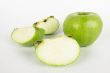 Yeşil elma ve elmanın yarısı beyaz arka planda izole edilmiş.
