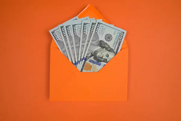 Vista Dall Alto Una Busta Arancione Con Dollari Sfondo Arancione — Foto Stock