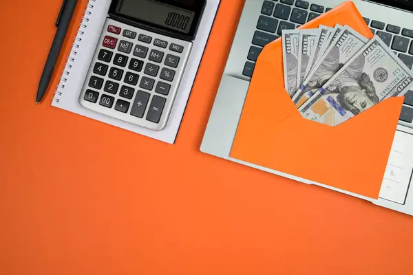 Laptop Busta Arancione Con Dollari Sfondo Arancione — Foto Stock