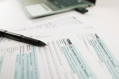 Vergi zamanı konsepti. Beyazlar için ofis malzemeleri içeren vergi formu. Finansal belge. Vergi Formu 1040. Nisan Vergi Zamanı.