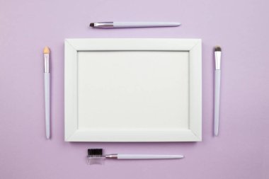 Makyaj konsepti. Üst görüntü fotoğrafı. Profesyonel dekoratif kozmetik seti, makyaj araçları ve aksesuarlar fotokopi alanı olan bir pastel mor arkaplan üzerinde