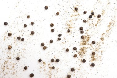 Beyaz arkaplanda karabiber taneleri ve toz izole edilmiş.