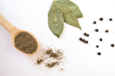 Beyaz arka planda kurumuş defne yaprağı ve karabiber. Baharatlar, izole edilmiş.