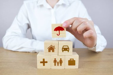 Sağlık sigortası, hayat sigortası ve güvenlik, sağlık ve planlama için insan eli taşları. Tahta küp kulesiyle gelecek, yatırım ve emeklilik 