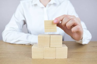 El kadını piramidin tepesine odun bloğu koyuyor, İnsan kaynakları, sosyal ağ, değerlendirme merkezi konsepti, kişisel denetim veya CRM