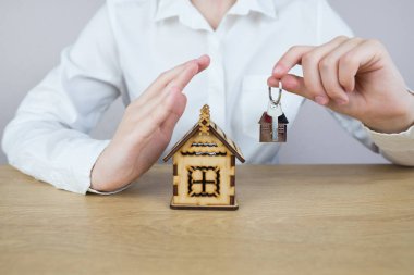 Emlakçı. Bir evin taksitle alınıp satılması için yapılan anlaşmayı sonuçlandırın. ve ev. İş kadını ya da emlakçı evin anahtarını tutuyor.