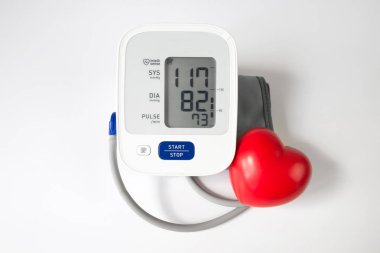 Tıbbi elektronik tonometre ve beyaz arka planda kırmızı kalp..