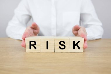 Risk yönetimi konsepti. Bir kadın tahta blokları tutuyor ve 