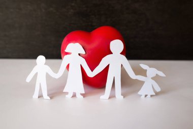 Yürekli aile kâğıdı silueti. Aile kağıdı kırmızı kalbi, kalp sağlığı, aile sağlık sigortası konsepti, Dünya Kalp Günü, Dünya Sağlık Günü.
