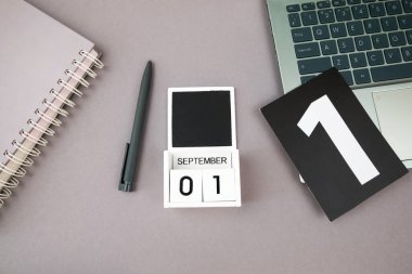 Çalışma alanı. Dizüstü bilgisayarı aç, takvim gri arkaplanda. Üst görünüm, boşluğu kopyala. Okula dönelim. 1 Eylül kavramı.
