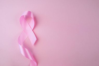 Yumuşak pembe arkaplanlı pembe göğüs kanseri kurdelesi..