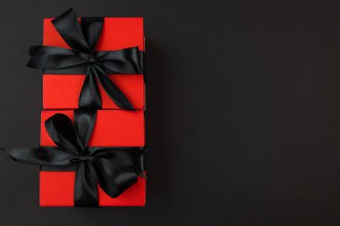 Üst görünüm fotoğraf kırmızı hediye kutuları ile siyah yay ile izole siyah arkaplan fotokopi alanı ile.