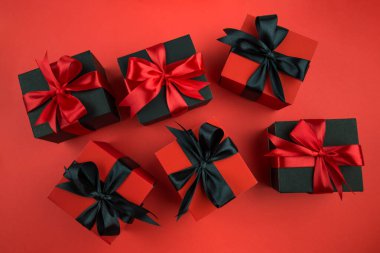 İzole edilmiş kırmızı arka planda fiyonklu hediye kutularının üst görünümü.