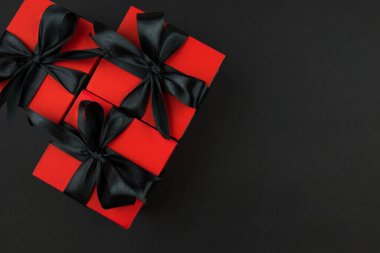 Üst görünüm fotoğraf kırmızı hediye kutuları ile siyah yay ile izole siyah arkaplan fotokopi alanı ile.