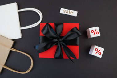 Arkaplanda hediye kutusu ve alışveriş poşetleri var. Kara Cuma indirimi. Pankart.