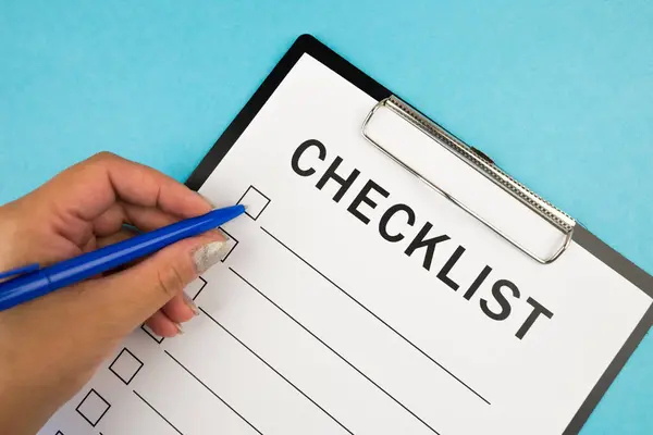 Güvenlik denetimi ve risk değerlendirmesi sırasında boş bir kontrol listesi. Güvenlik kontrol listesi formu. Kalemli bir el kontrol listesine kene yazar..