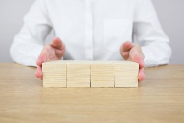 Ahşap masada dört boş tahta küp tutan kadın eller. Metin, simge, sembol ya da logo, yaratıcı ve yönetim konsepti. Metin için yer