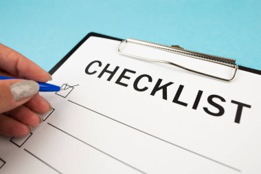 Güvenlik denetimi ve risk değerlendirmesi sırasında boş bir kontrol listesi. Güvenlik kontrol listesi formu. Kalemli bir el kontrol listesine kene yazar..