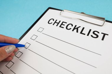 Güvenlik denetimi ve risk değerlendirmesi sırasında boş bir kontrol listesi. Güvenlik kontrol listesi formu. Kalemli bir el kontrol listesine kene yazar..