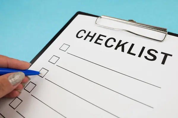 Güvenlik denetimi ve risk değerlendirmesi sırasında boş bir kontrol listesi. Güvenlik kontrol listesi formu. Kalemli bir el kontrol listesine kene yazar..