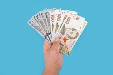 Dolarlar ve hryvnialar mavi arka planda..