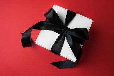 Kırmızı arka planda siyah kurdeleli beyaz kutu