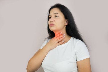 Mutsuz genç esmer, gözleri kapalı boğaz ağrısı çeken boynundaki kırmızı iltihaplı bölgeye dokunan, stüdyo arka plan serisi.