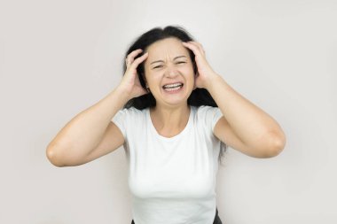 Genç, tatminsiz gergin kadın, kollarını aç, çığlık at, histeri, bak, kamera, gri arka planda izole edilmiş..