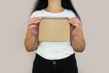 Bir kadın elinde boş bir karton çarşaf tutuyor..