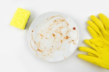 Sarı sünger lastik eldiven ve izole edilmiş beyaz arka planda kirli plaka. Kirli bulaşık konsepti, bulaşık yıkama..