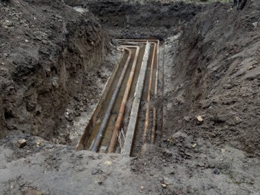 Kanalizasyon borusu patladı. Kanalizasyon borularının tamiri için kazılmış bir çukur. Özel bir evde bakım ve bakım. ev bakımı