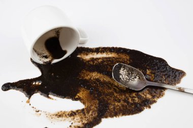 Beyaz arka planda beyaz bir fincandan dökülen kahve, yakın plan.