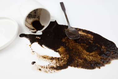 Beyaz arka planda beyaz bir fincandan dökülen kahve, yakın plan.