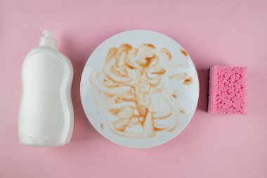 Kirli beyaz tabak şişesi pembe arka planda bulaşık deterjanı. Üst görünüm. Temizlik konsepti, temizlik hizmetleri..