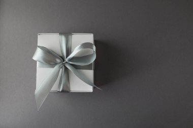 gri arkaplanda saten kurdeleli gri hediye kutusu, üst görünüm, boşluk kopyala.